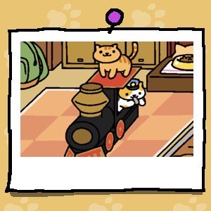 Conductor Whiskers wears a conductor's hat and blows a whistle. The cat is looking out the window of the cardboard train. Fred is a light orange cat with darker orange stripes. Fred stands on top of the cardboard train.
