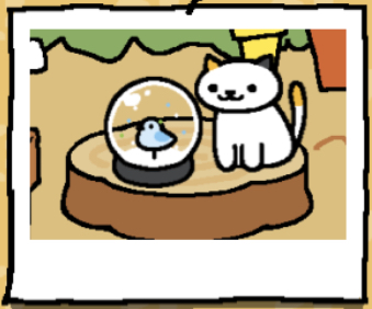 Dottie is a white cat with one black ear and one light orange ear. Their tail has a light orange spot at the top of it. Dottie looks at a snow dome.