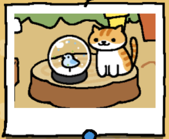 Pumpkin is a light orange cat with darker orange stripes on their head, back, and tail. The lower part of this cat's face is white, as is their belly and front paws. Pumpkin looks at the snow dome.