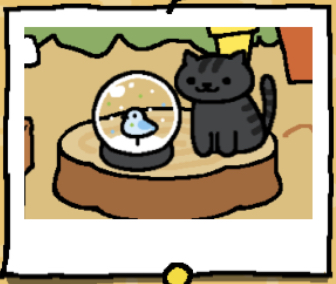 Willie is a black cat with black stripes on their head, back, and tail. Willie is looking at the snow dome.
