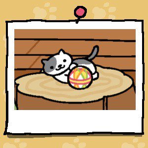 A grey and white cat plays with a fabric ball.