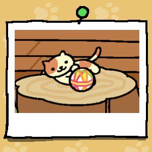 A yellow cat with light brown spots on their head, back and tail plays with a fabric ball.