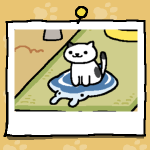 A white cat with a few black spots sits on a cooling mat that is shaped like a Manta Ray.