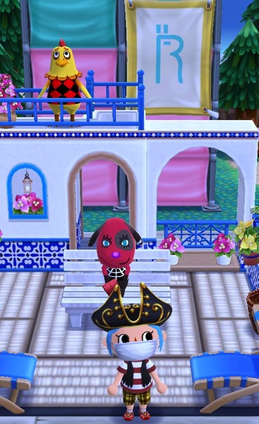 My Pocket Camp character is wearing pirate clothing and a large pirate captain's hat. They are standing in the Port Resort part of their campground.