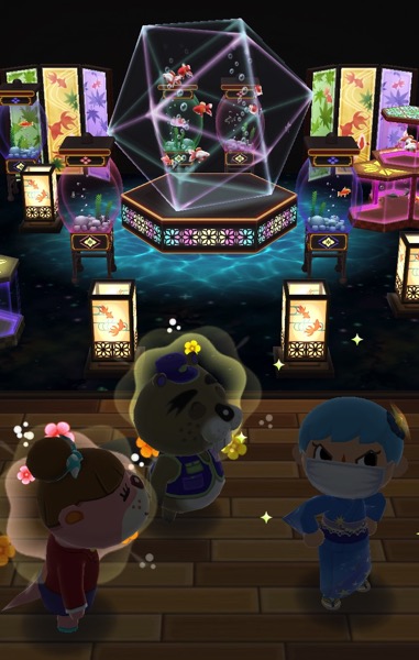 My Pocket Camp character stands near Chip and Lottie. Behind them is a room stuffed full of aquariums and two screens that are decorated with fish.