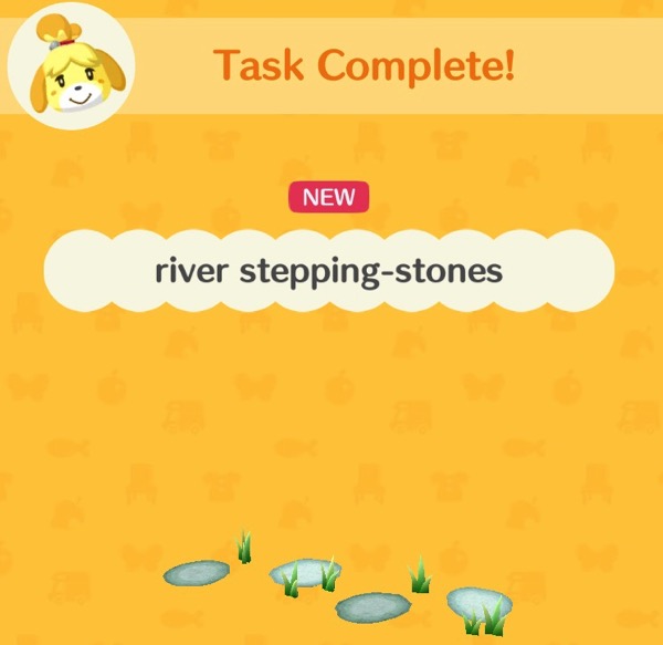 A box showing a small collection of river stepping stones. There is some grass around the stones.