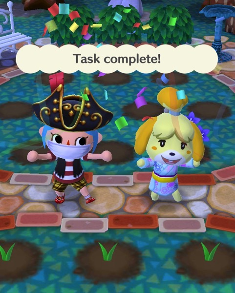 My Pocket Camp character wears pirate clothing. Isabelle is wearing a kimono-like outfit. Above them are the words "task complete".
