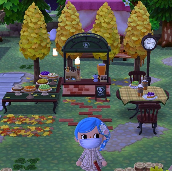 My Pocket Camp character stands in front of the final arrangement of the café. It is now less cluttered and easier for animal friends to use it.