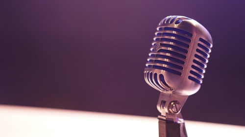microphone by Matt Botsford on Unsplash. The background is mostly purple.