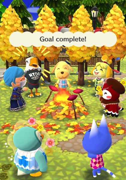 A group of Pocket Camp animal friends stand around a pile of leaves that is on fire. There are three sticks in the ground around the leaves. Each stick holds a sweet potato that is being roasted.