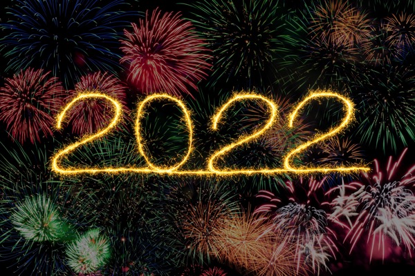 The numbers 2022 are written in bright yellow. There are fireworks behind it. Photo by Morti Knoringer on Unsplash.