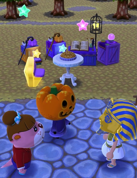 Lottie and Jack stand near my Pocket Camp character (who is wearing a King Tut costume). Behind them are some items from the event. 