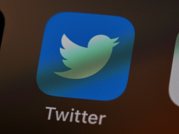 A screenshot of the light blue Twitter bird logo on a darker blue square. It is on a smartphone. Below it is the word "Twitter". Photo by Brett Jordan on Unsplash.