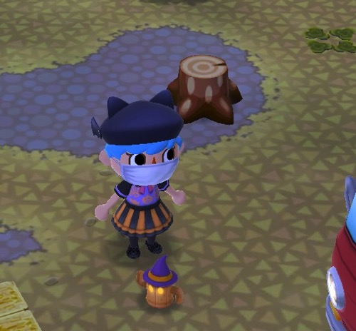 My Pocket Camp character stands in front of a Fright-Night Gyroidite that looks like a pumpkin with glowing eyes. It is wearing a purple witch's hat.