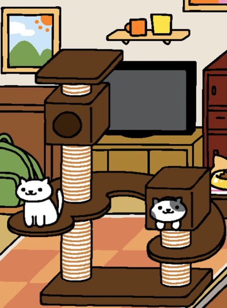 Snowball is a white cat who sits on the rounded end of the Cat Metropolis. Snowball looks out at the viewer. Willow is a white cat with large grey spots who is inside the lower box of the Cat Metropolis. Willow's face and paws stick out.