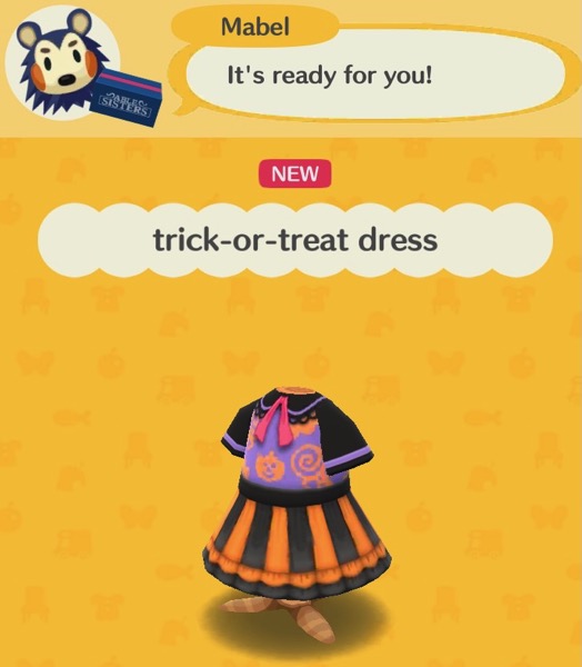 The trick-or-treat dress reminds me of the plastic Halloween costumes that stores used to sell. This dress has short, black, sleeves, with purple lines around the edges. A pink ribbon is attached to the collar. The top of the dress is purple with images of jack-o-lanterns and lollipops. The skirt has a black ribbon around the top of it and alternates in black and orange horizontal lines. The bottom of the dress is black.