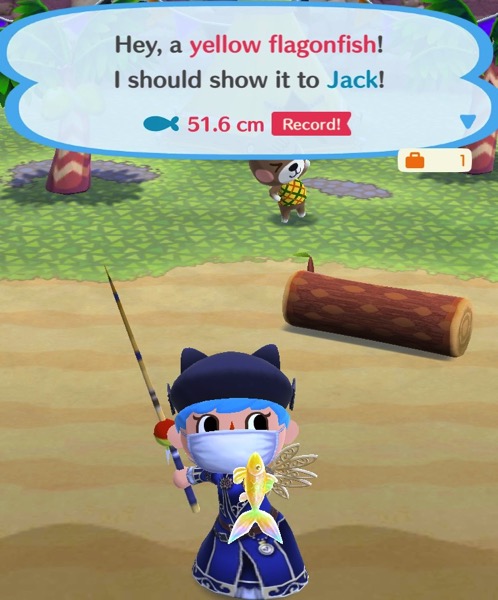 My Pocket Camp character holds up one yellow flagonfish.