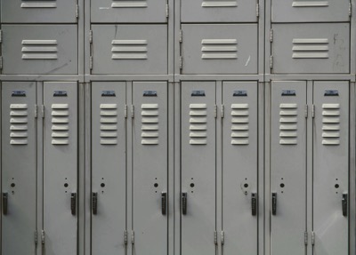 A row of gray lockers at a school, by Joshua Hoehne on Unsplash