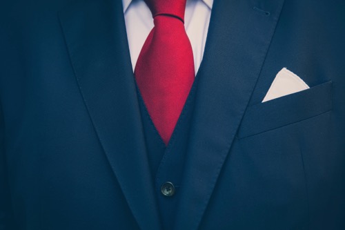 A close up of a blue suit and a red tie by Marcus Spiske on Unsplash